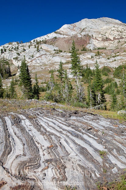 Limestone formations form wave-like patterns underneath towering limestone cliffs, Eagle Cap Wilderness, Oregon