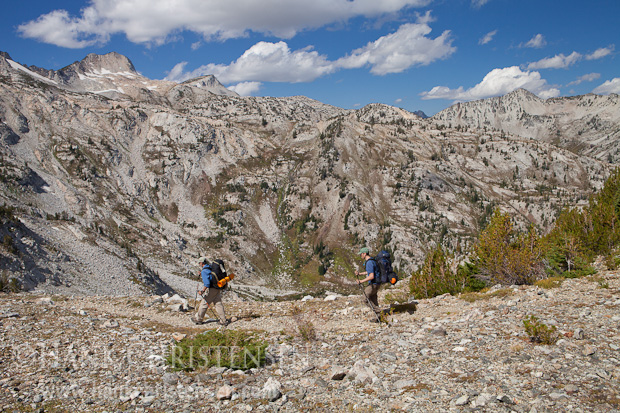 Two backpackers descend the north side of Hawkins Pass. Eagle Cap can be seen peeking over the ridge, Eagle Cap Wilderness, Oregon
