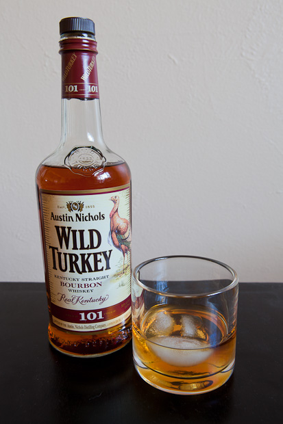 bottle of Wild Turkey burbon with a glass and ice