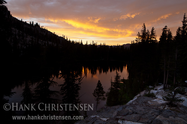 The dramatic skies of sunset are reflected in one of lakes of the Ten Lakes chain, Yosemite National Park