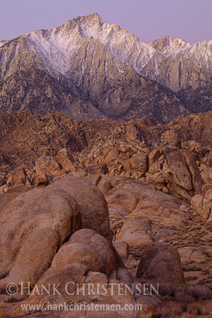 Dawn begins to light Mt. Langley and the wild rock formations of the Alabama Hills