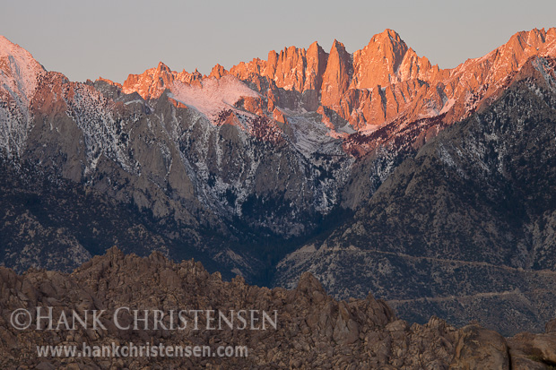 The peak of Mt. Whitney glows red in the early morning light