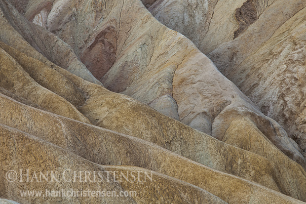 Muted light plays across the ridges of rock at Zabriskie Point, Death Valley National Park