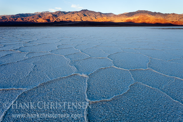 Sunlight moves down the mountains to the west of Salt Creek, now a dried salt flat, Death Valley National Park