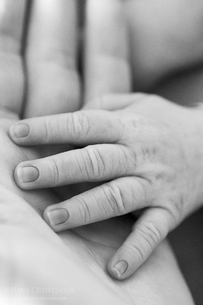 Nancy cradles Jake Jr's hand in her own.