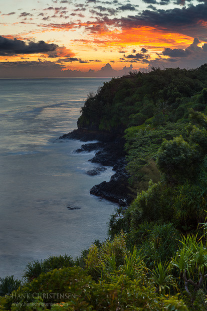 Clouds to the east light up over Kauai's north shore at sunrise