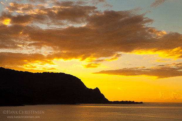 The sun sets behind the northern cliffs of the Napali coast, Hanalei Bay, Kauai