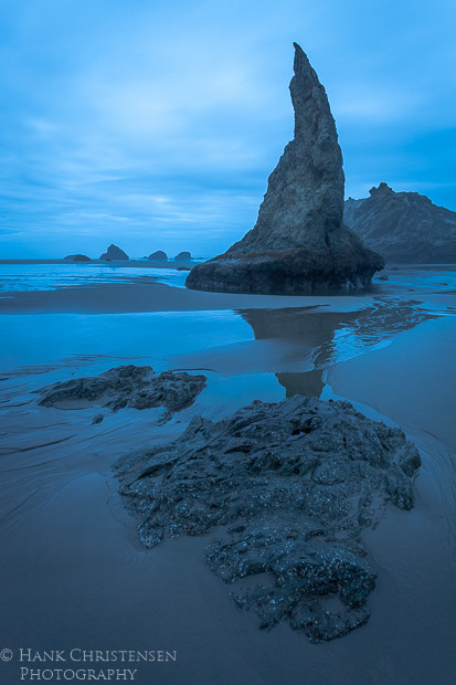 The sun rises on a blue, dreary day along Bandon Beach Oregon