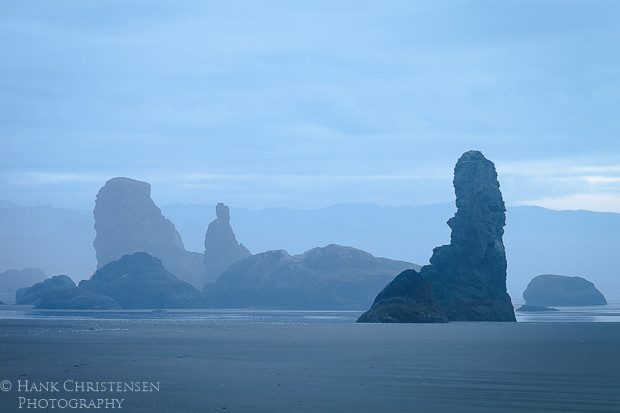 The sun rises on a blue, dreary day along Bandon Beach Oregon