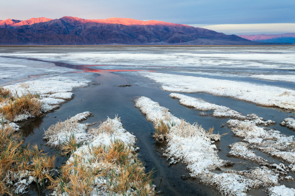 Sun creeps down the mountains west of the Cotton Ball Basin, Death Valley National Park