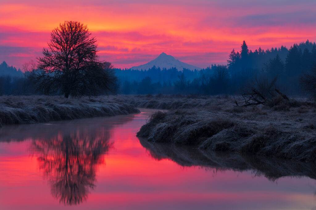Sunrise lights up the clouds behind Mt. Hood, reflected in the still waters of Salmon Creek, Vancouver, WA.