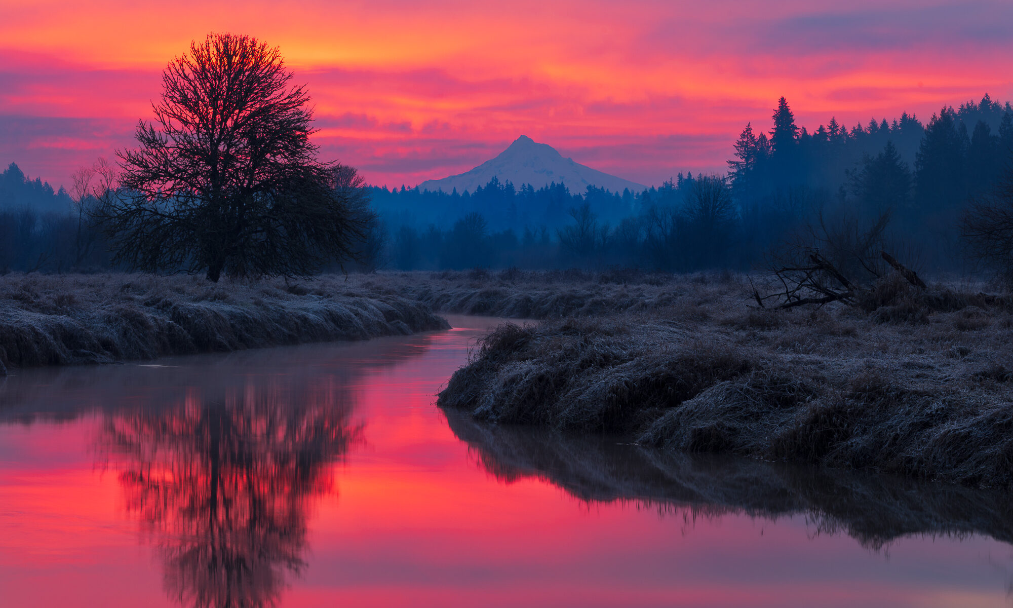 Sunrise lights up the clouds behind Mt. Hood, reflected in the still waters of Salmon Creek, Vancouver, WA.